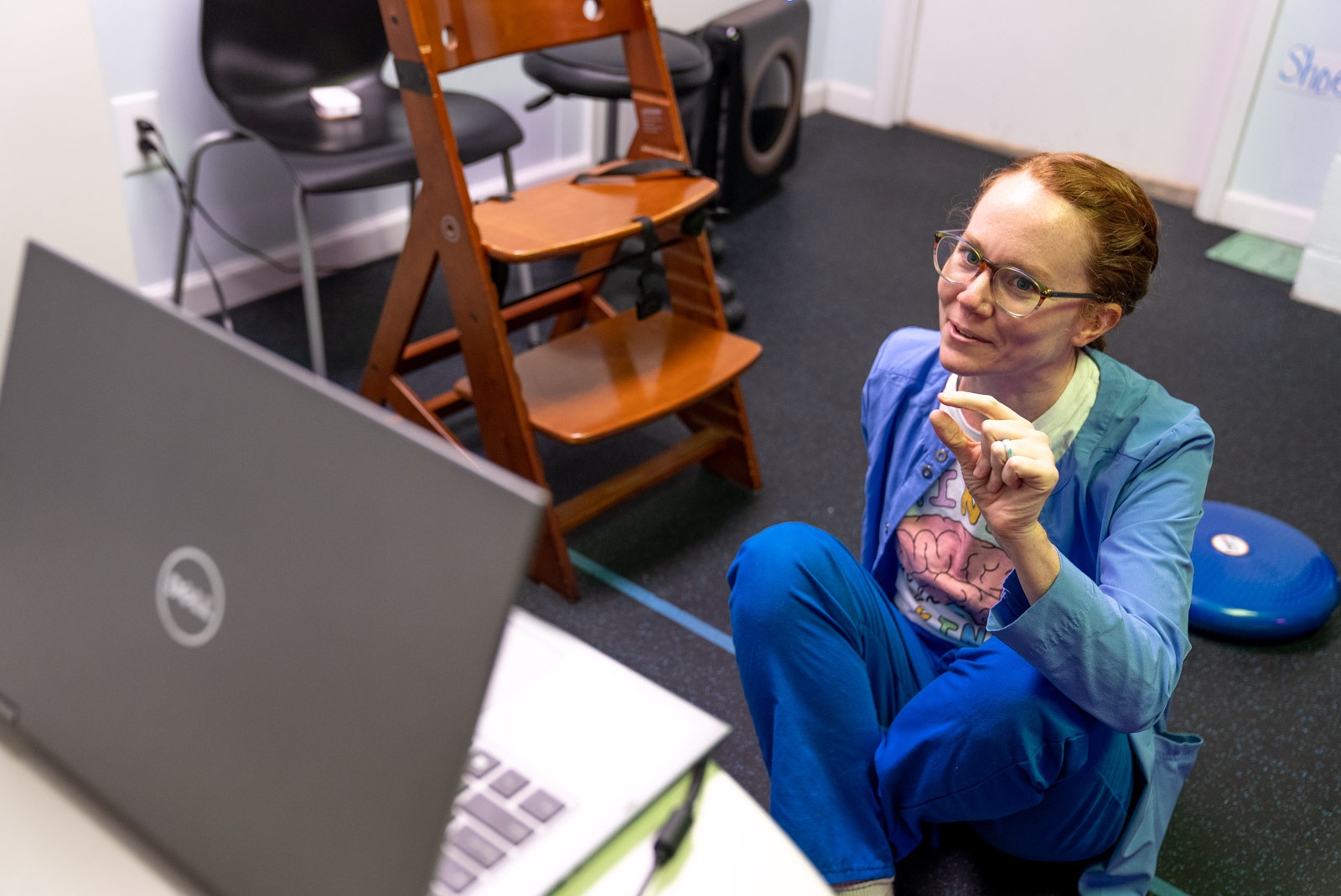 Therapist smiling at a laptop during a teletherapy session