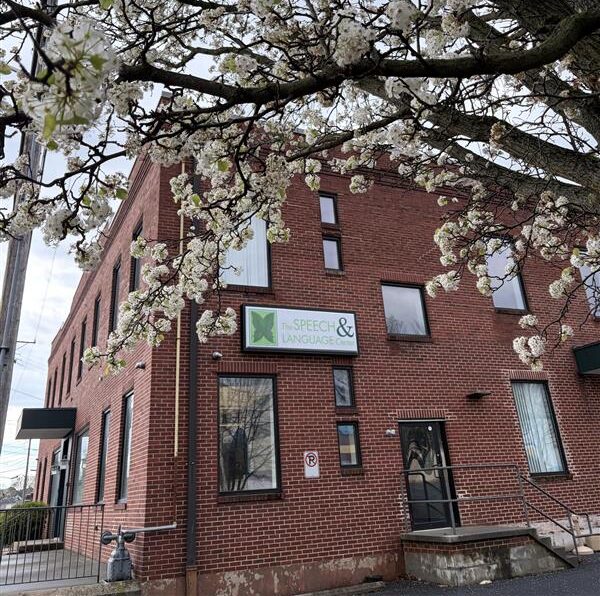 Brick building with The Speech & Language Center sign under a flowering tree