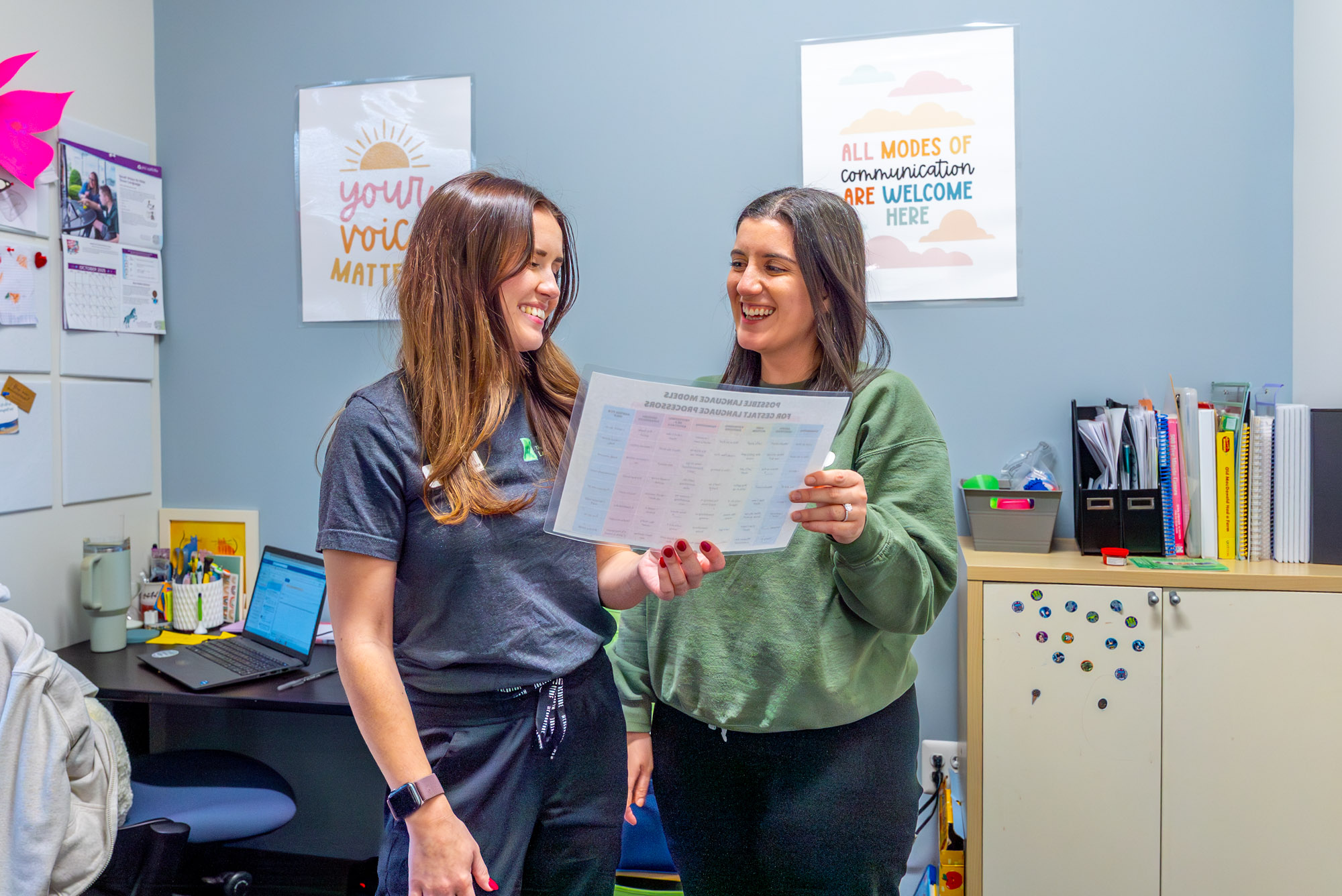 Two staff members reviewing a document in an office